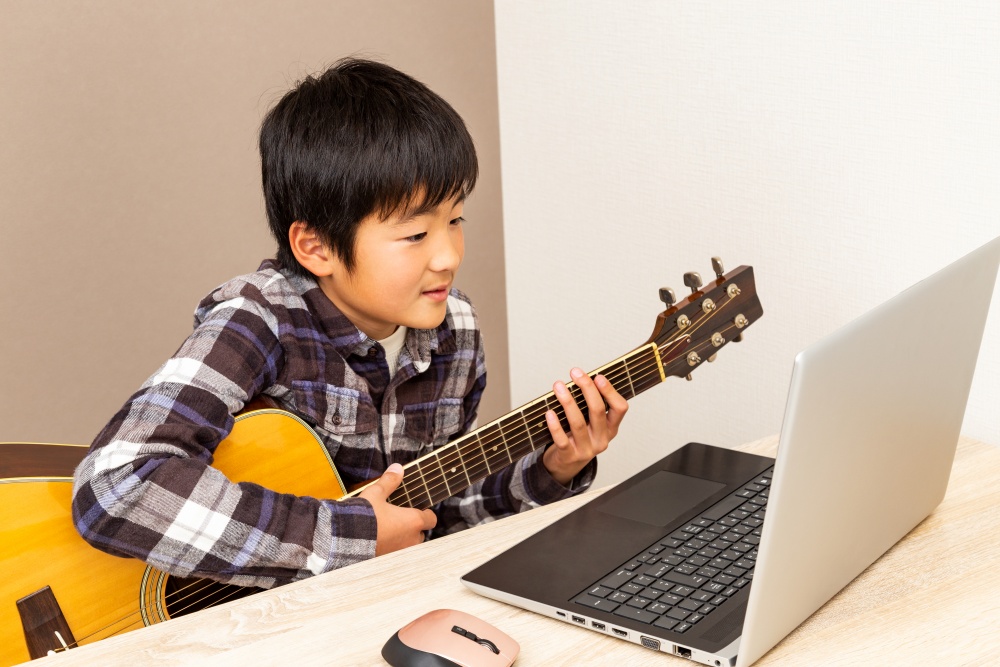 ギターを練習する少年